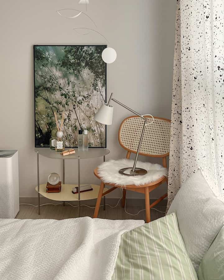 Natural beige-toned bedroom featuring a rattan wooden chair and matte acrylic steel side table
