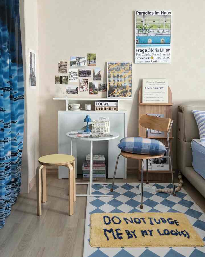 Beige-walled small dining room featuring blue curtains, rug, stools with cozy natural vibe