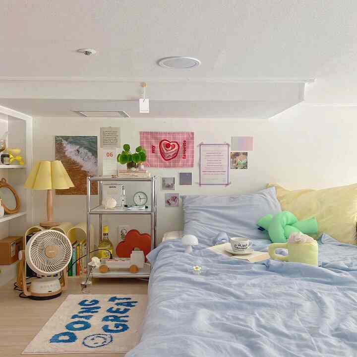 パステルブルーとイエローが調和したロフトの寝室、かわいい小物とポスターが配置された雰囲気のあるインテリア