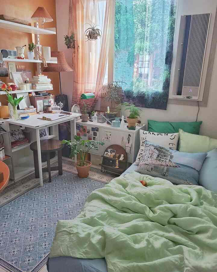 Pastel light green and white toned studio bedroom featuring rattan lamps and plant decor in a cozy space