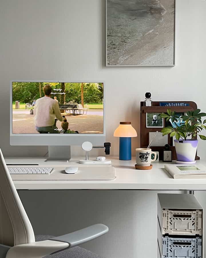 Bright white-toned home office featuring a sleek desk with an iMac and table lamp in a modern setting