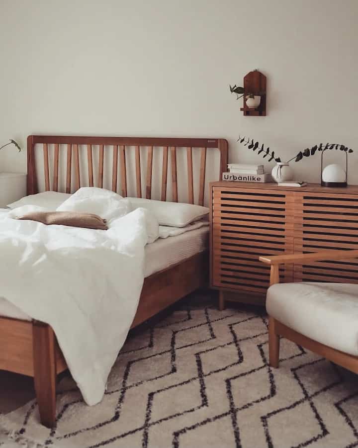 白と木目調が調和するナチュラルな寝室、木製ベッドと収納が配置された落ち着いた空間