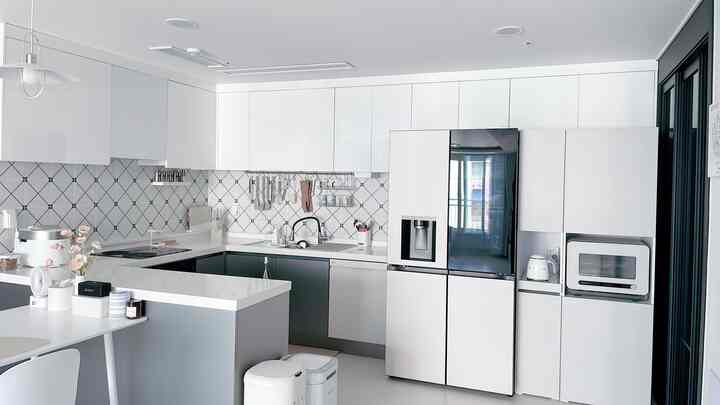 Modern kitchen space in white and gray tones, featuring LG Objet collection refrigerator and dishwasher, with clean and sleek design