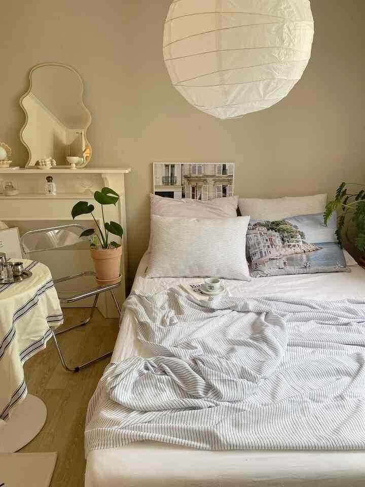 Natural tones and white harmonized bedroom space featuring bed, dining table, and plants with a cozy atmosphere