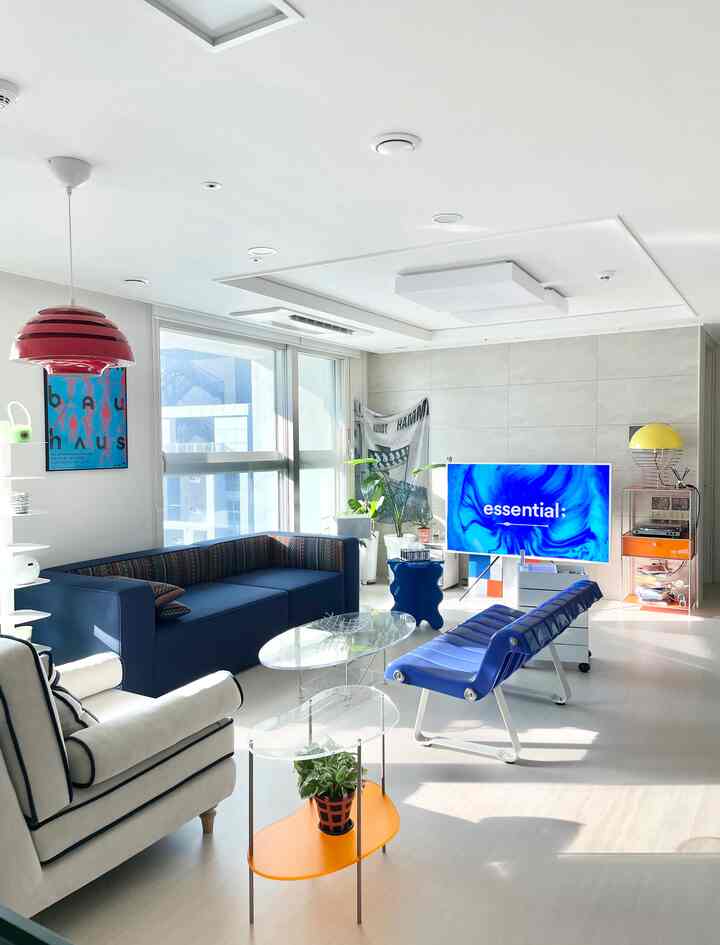 ブルーとホワイトの色調のリビング、モジュラーソファと透明アクリルテーブルが配置された明るく爽やかな雰囲気のインテリア