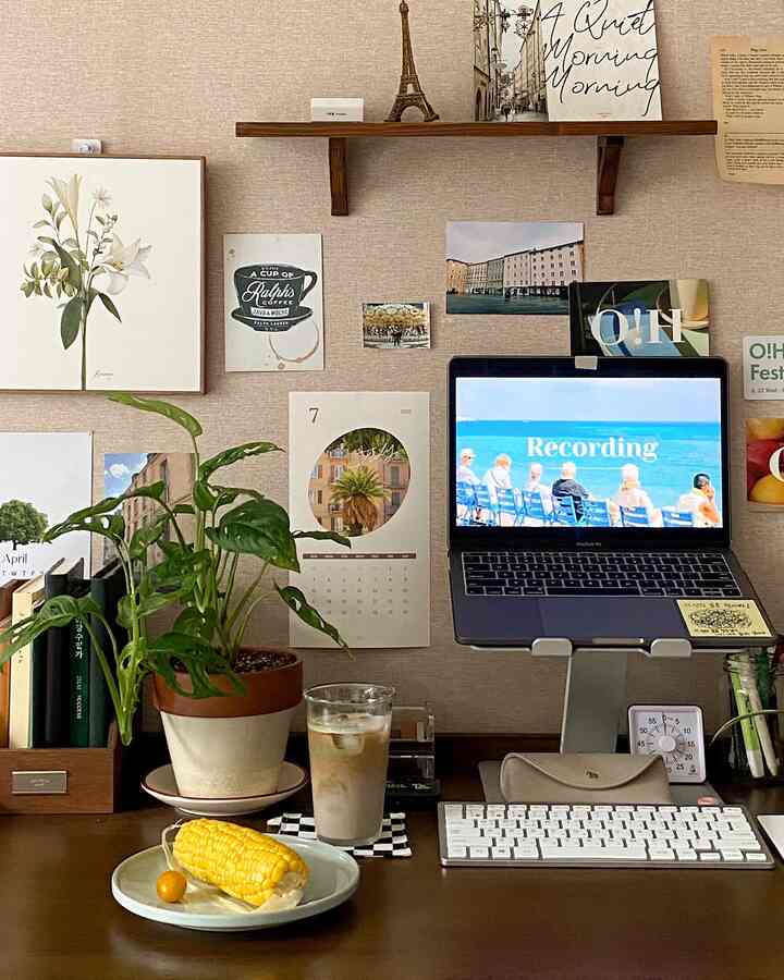 Wood tone and dark brown home office desk featuring plants and picture frames in a cozy setup