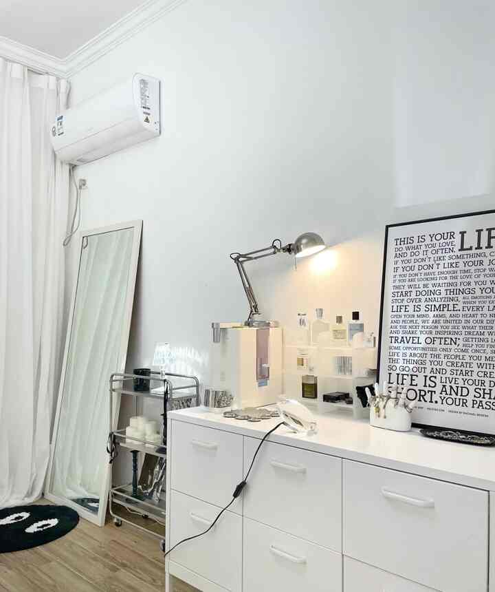A minimal modern space in white and wood tones featuring a dresser and full-length mirror, creating a simple home office vibe
