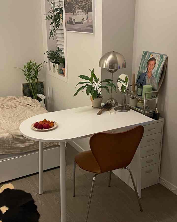 Cozy single household bedroom in white and brown tones featuring a desk and chair in a natural modern style space
