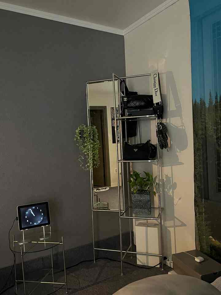 Gray-toned wall and modern metal full-length mirror with shelving create a clean indoor space