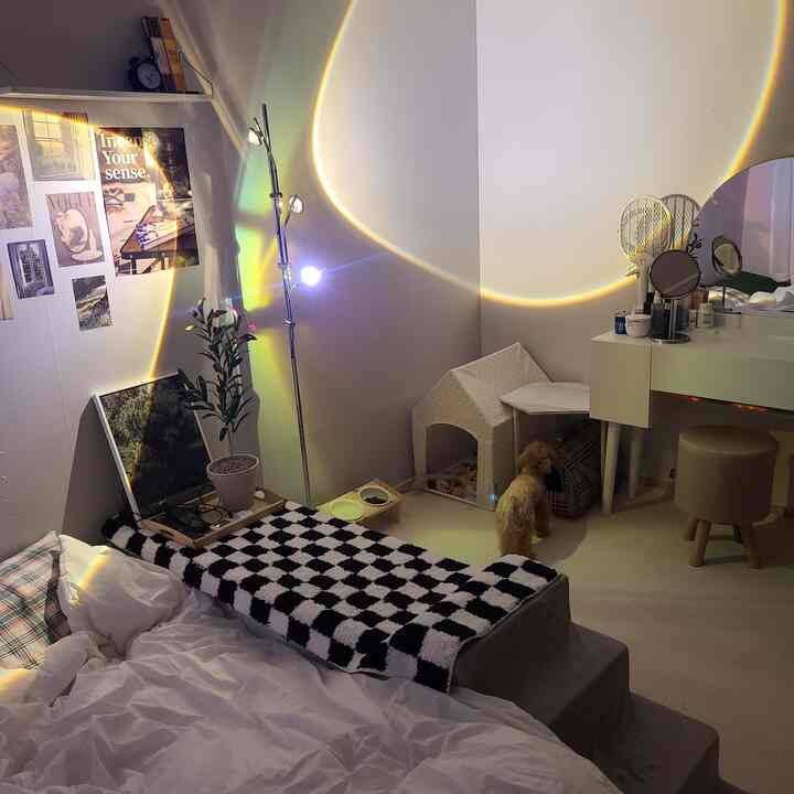 白を基調とした寝室で、犬のためのペットスペースと化粧台が配置された温かみのある居心地の良いインテリア