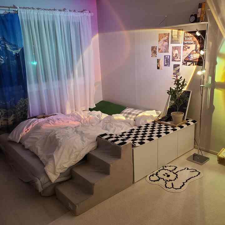 White and beige toned single bedroom featuring a low bed frame and pet steps, creating a cozy atmosphere