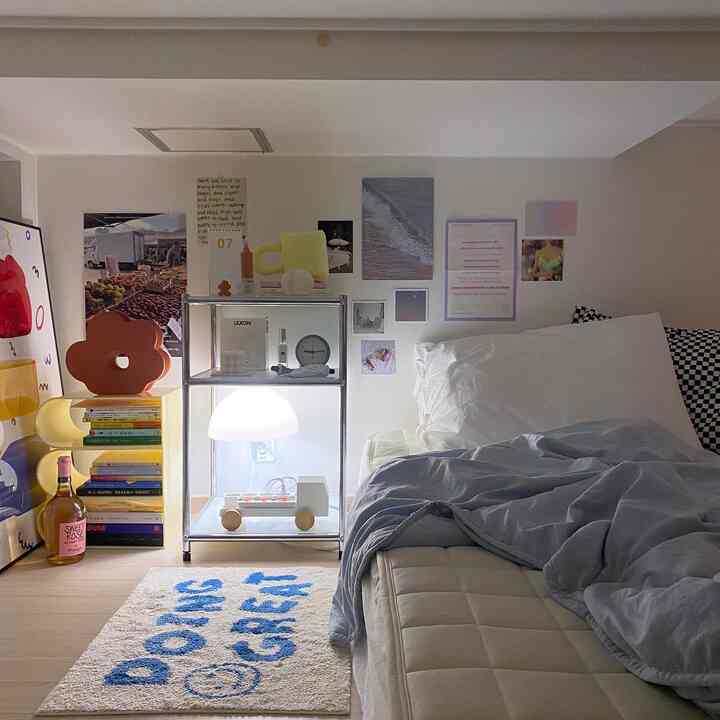 White and blue toned bedroom featuring a bed, nightstand with lamp, wall decor, and cozy simple atmosphere