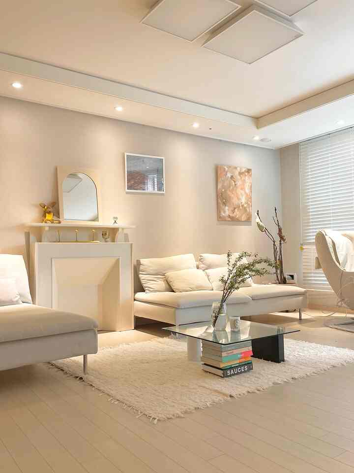 Bright natural tone living room featuring cream sofas and glass coffee table with cozy atmosphere
