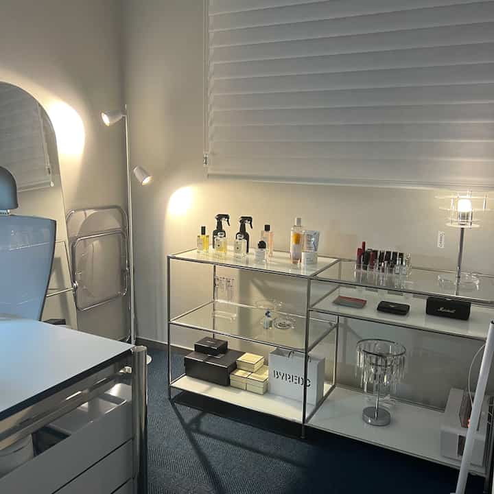 White and modern toned home office space featuring modular shelving and lighting with a clean design