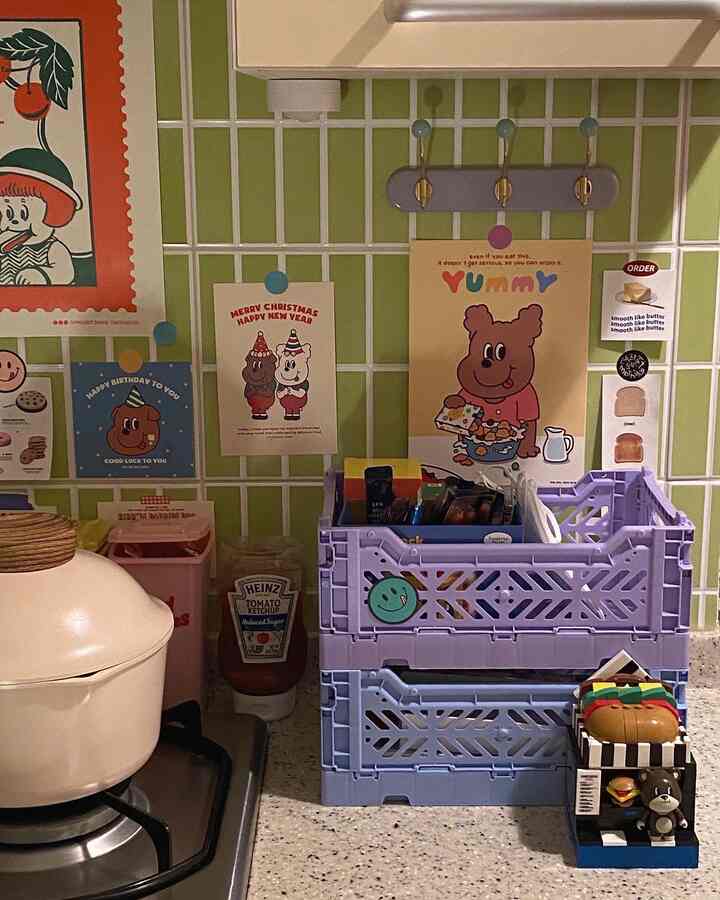 Kitchen space with white stove and green tiled wall, featuring folding storage boxes and kitchen accessories in a cozy retro style