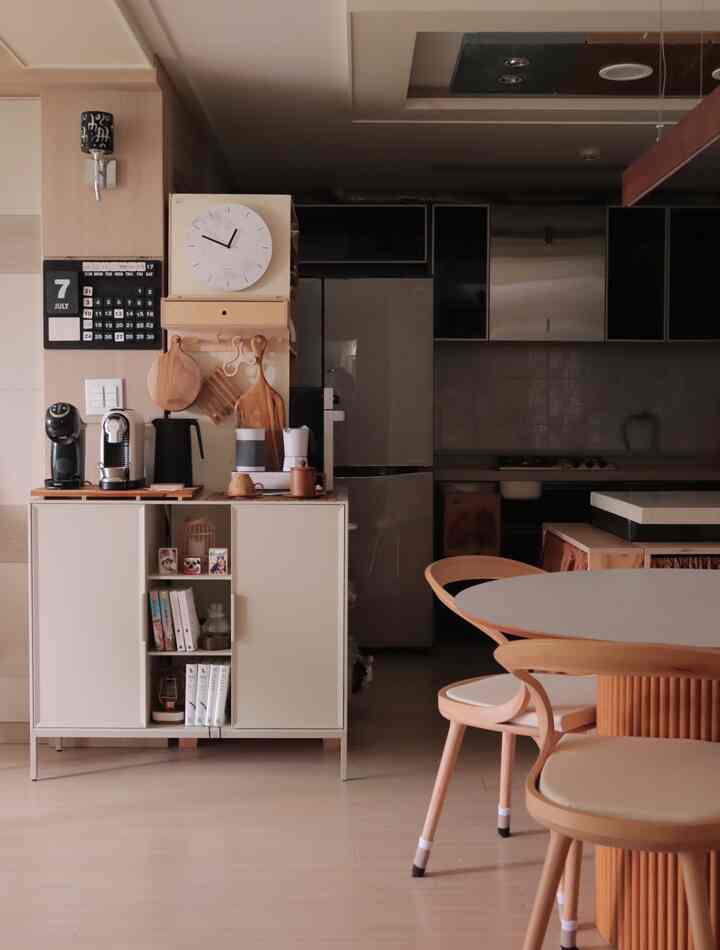 Natural modern kitchen in wood tone and white, featuring a small storage cabinet with home cafe machines and wall shelf, creating a cozy atmosphere