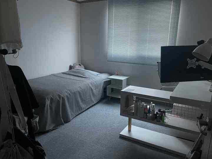 白とナチュラルカラーが調和するコンパクトな寝室、ベッドとデスク、ブラインドが配置された清潔感のある雰囲気のインテリア