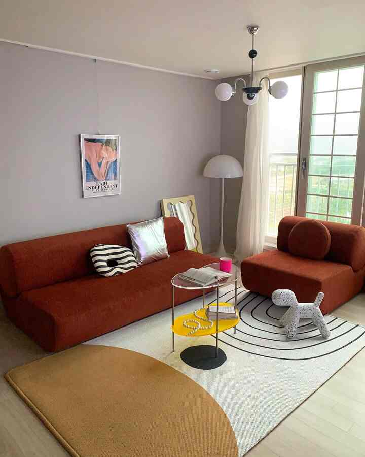 Modern living room in white and brown tones featuring large sofa, curtains, and floor lamp with a stylish atmosphere