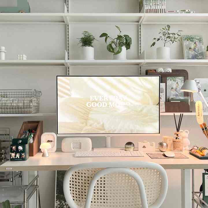 Bright white-toned home office featuring a large central monitor, white desk, and chair in a clean workspace