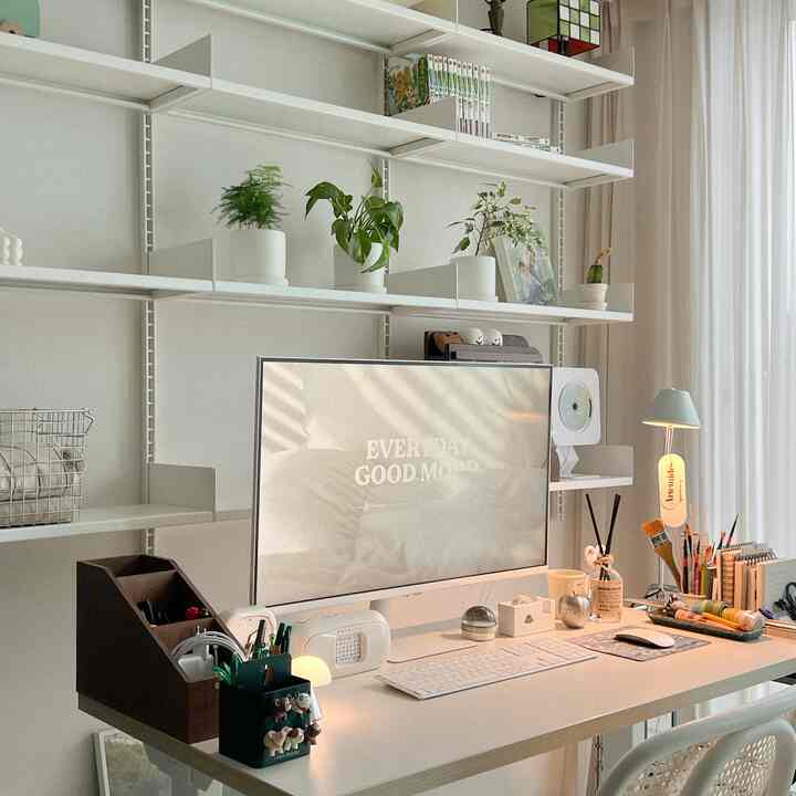 White and natural-toned home office space featuring a large monitor and organized desk with a simple modern atmosphere