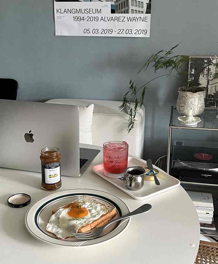 White and natural toned home office space featuring round table with plants and tray, cozy atmosphere
