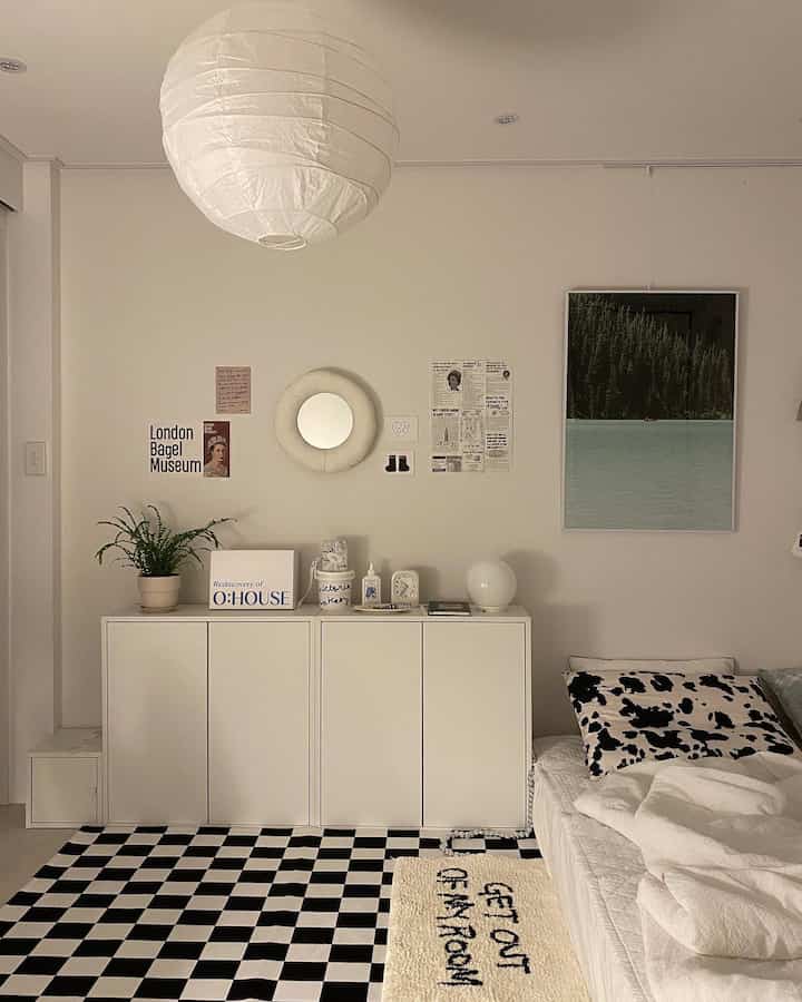 White-toned bedroom featuring large pendant light and clean white storage cabinets in a simple modern space