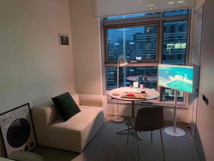 白とグレーのトーンのリビング空間、白いソファと円形のダイニングテーブルが配置されたモダンで居心地の良いインテリア