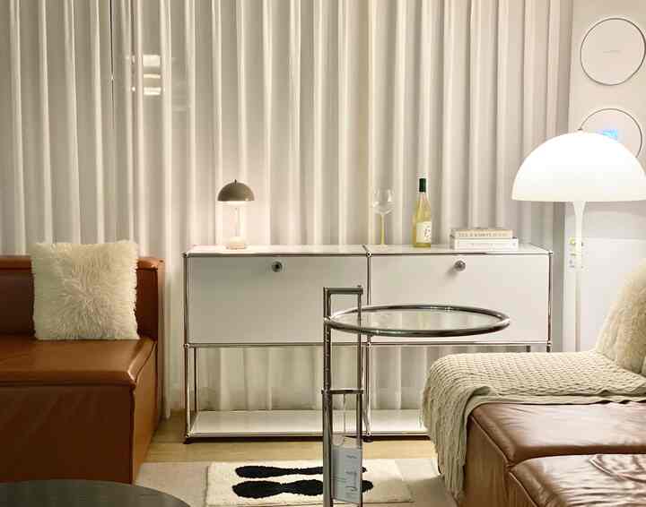 White and brown toned living room featuring modular furniture and leather sofas creating a cozy, simple modern space