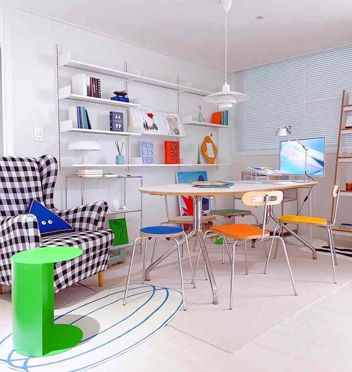 White-toned mid-century modern living room featuring checkered sofa and colorful chairs in a bright, clean space