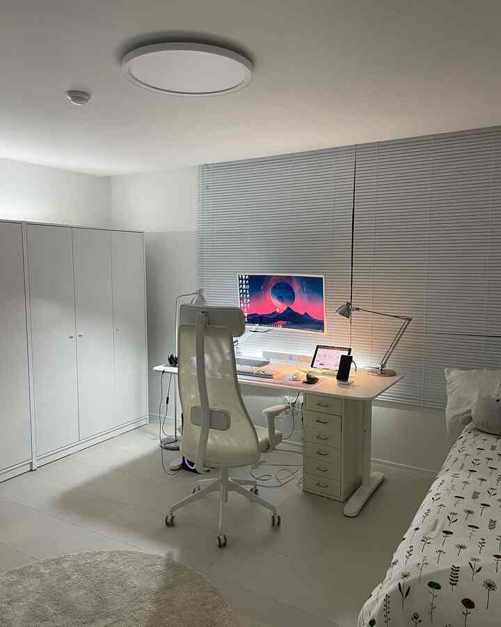 ホワイトトーンのワンルーム寝室兼ホームオフィス、机とオフィスチェアが配置された清潔感あるインテリア