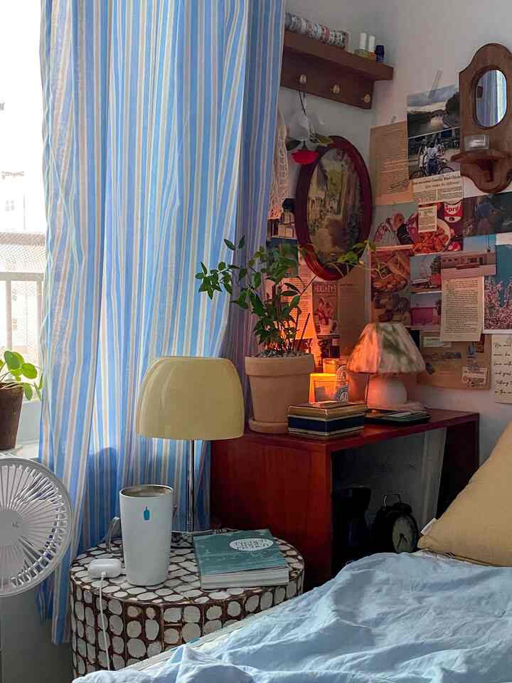 柔らかな青色の寝室、ヴィンテージ家具と植物が配置された雰囲気のあるインテリア