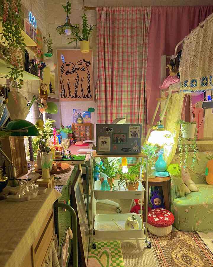 Cozy home office space with pink and green tones featuring a rolling cart with laptop and abundant plants creating a warm atmosphere