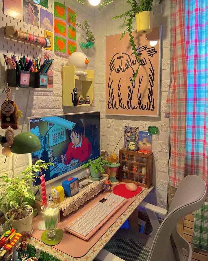 ピンク色調のコンパクトなホームオフィス、デスクやオフィスチェア、植物や額縁が配置された雰囲気のある作業空間