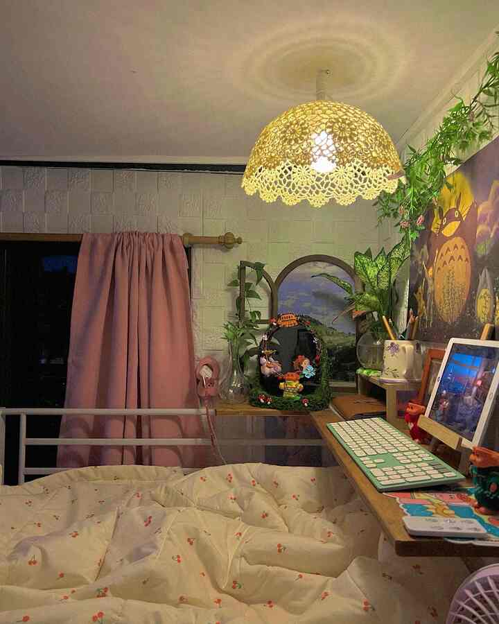 Ivory bedding and pink curtain in a compact loft bedroom with a knit lampshade light