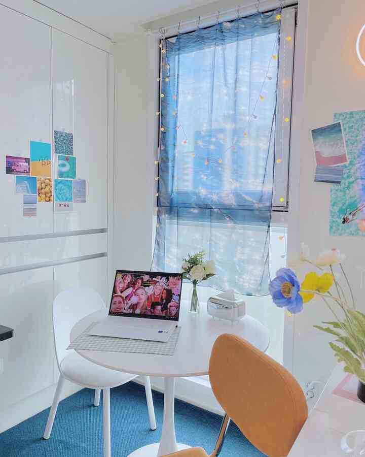 A modern and simple kitchen and dining room in white and blue tones featuring a round table and two dining chairs