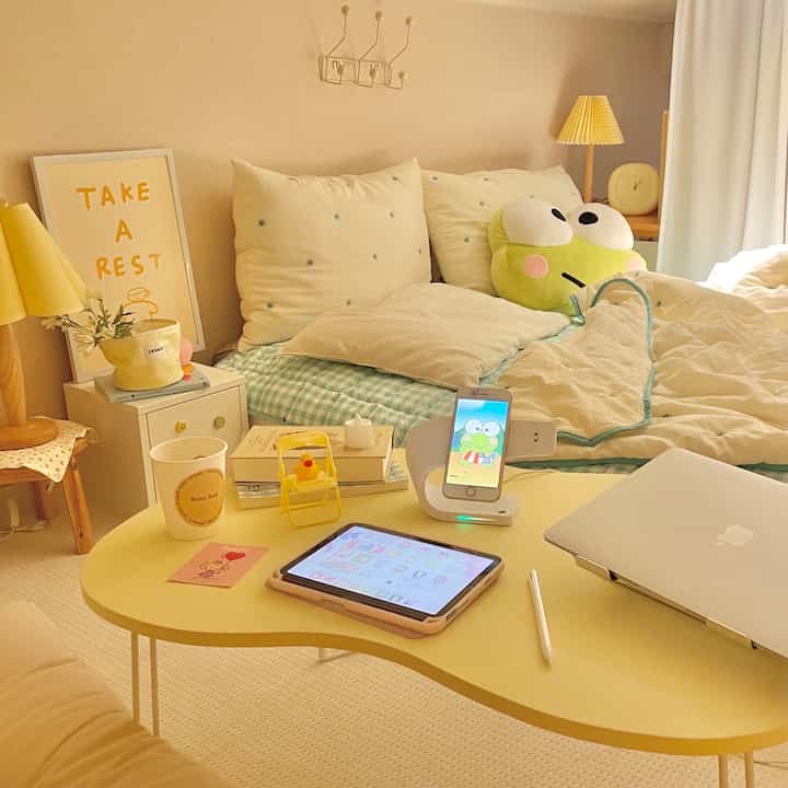 Warm yellow-toned loft bedroom featuring a low yellow table and cute frog cushion creating cozy atmosphere