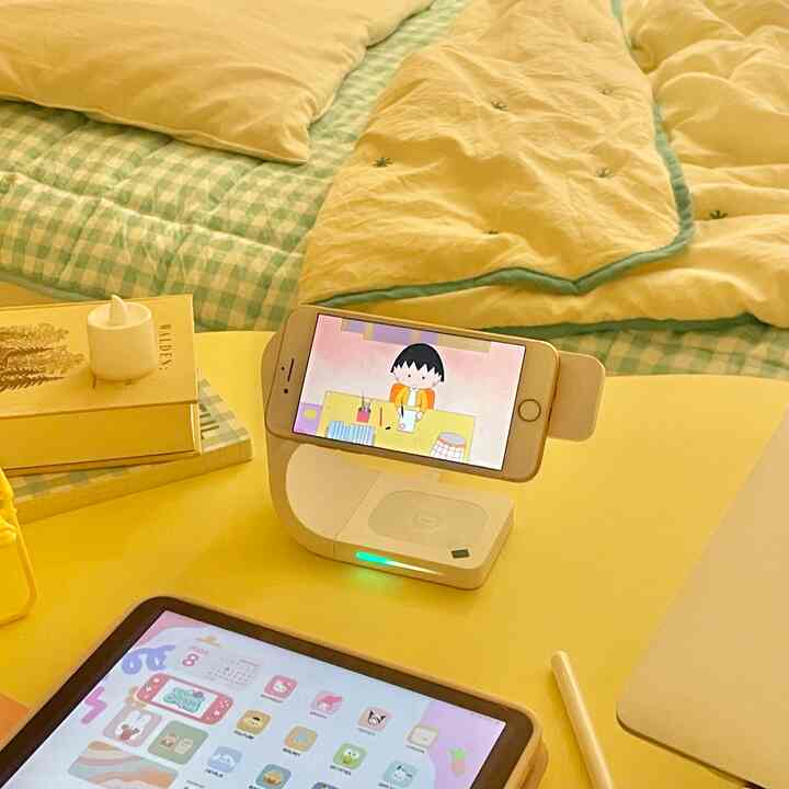 Yellow and green toned kids' bedroom featuring a desk with tablet and smartphone stand in a modern setting