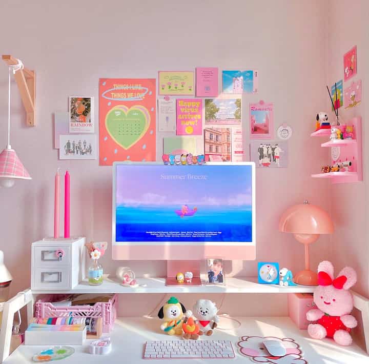 Pink-toned home office space featuring a white desk and iMac, cozy corner workspace with focused desk decor
