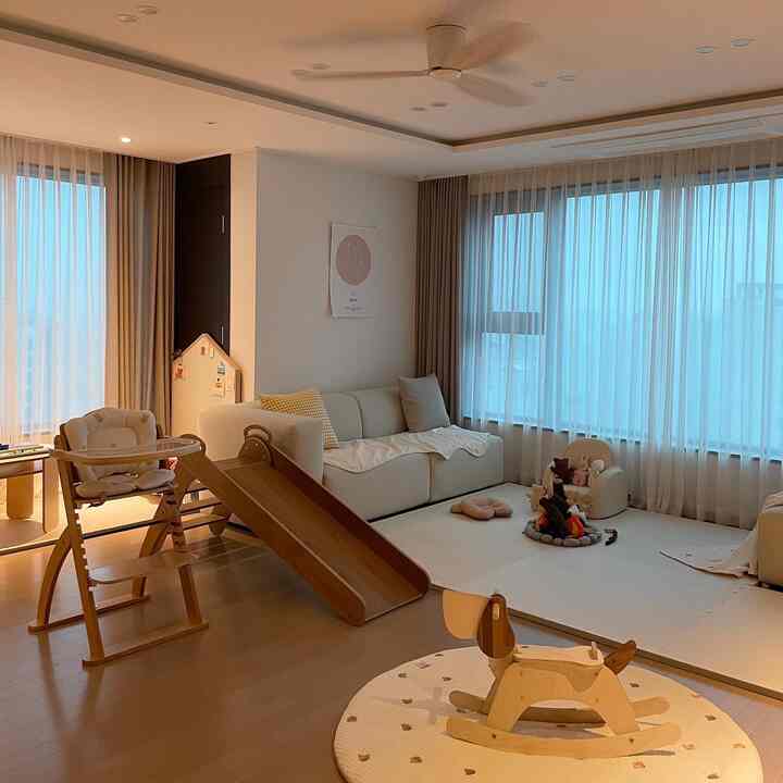 Natural beige and wood-toned living room featuring baby products and a cozy play area with a warm atmosphere