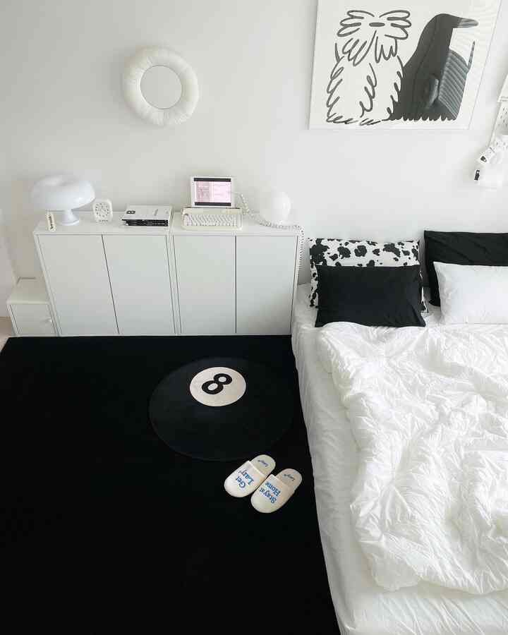 黒と白のモノトーンの寝室、8ボール柄のラグと白いベッドが配置されたシンプルでモダンなインテリア