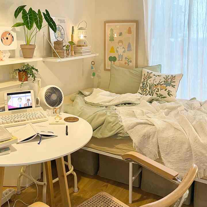 Natural-tone single household room featuring bed, workstation, cushions, and curtains with a warm atmosphere