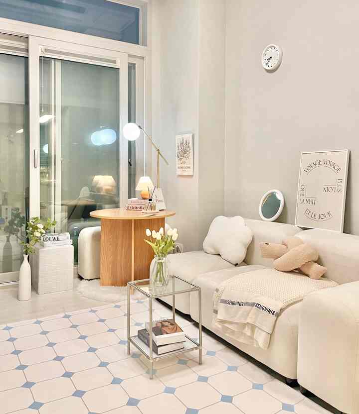 Natural-toned living room featuring a round wooden dining table and ivory sofa with cozy atmosphere