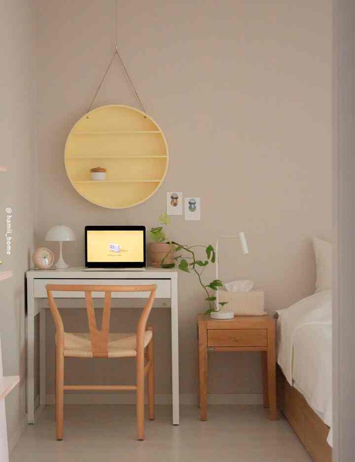 A simple and natural single household bedroom study space featuring white and wood tones