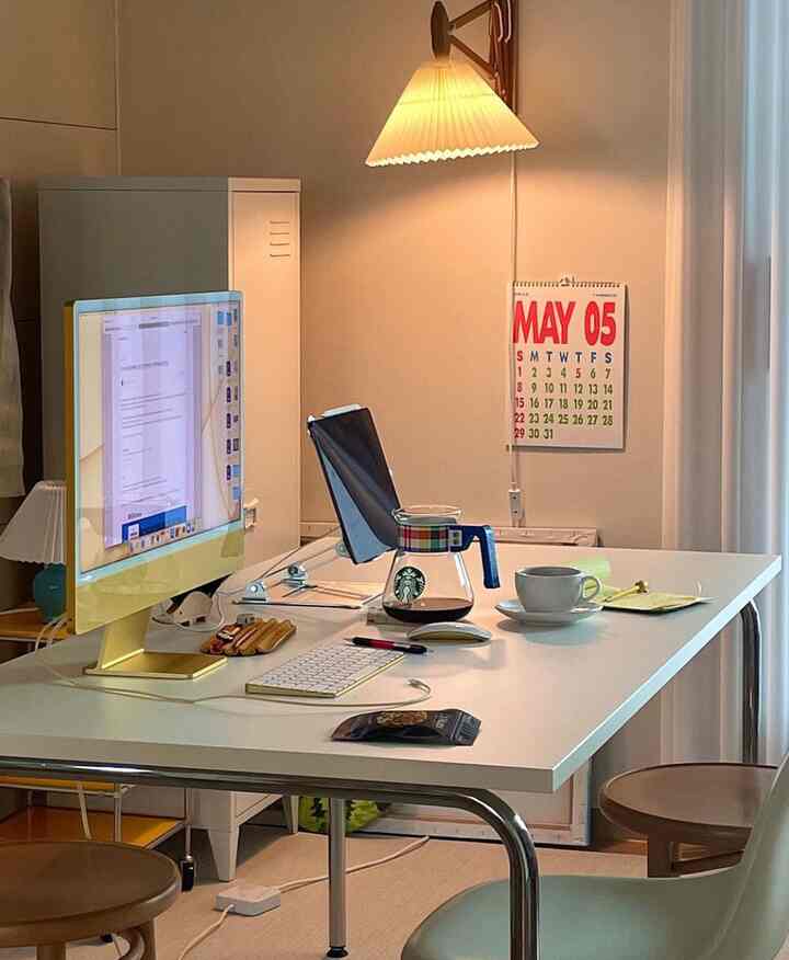 White-toned home office featuring a spacious desk, iMac, and coffee server with a clean and modern workspace atmosphere