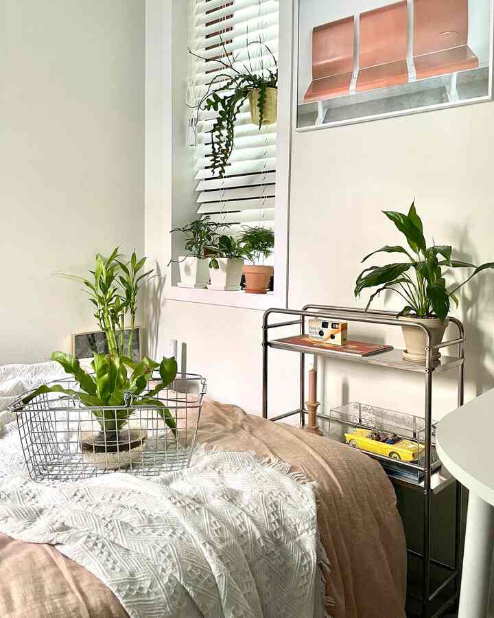 White and beige bedroom featuring plants on the bedspread, creating a simple and natural atmosphere