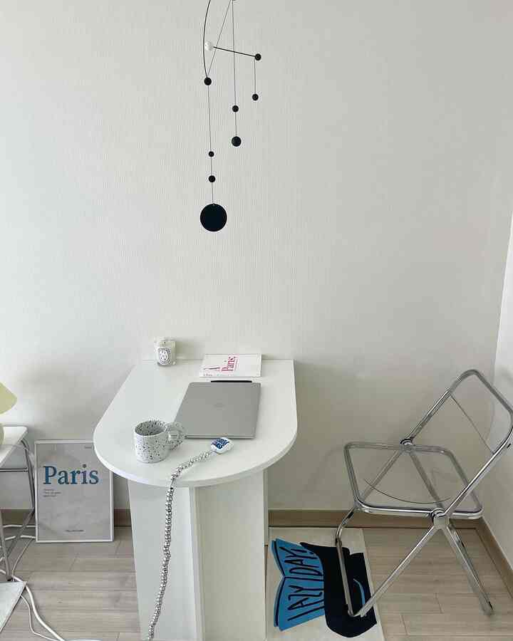 Clean white-tone home office featuring a transparent chair and minimalist desk with simple accessories, creating a minimal workspace atmosphere