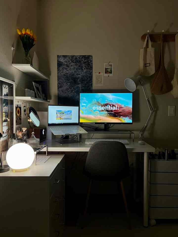 White and gray toned compact home office featuring desk and monitors in a minimalistic setup
