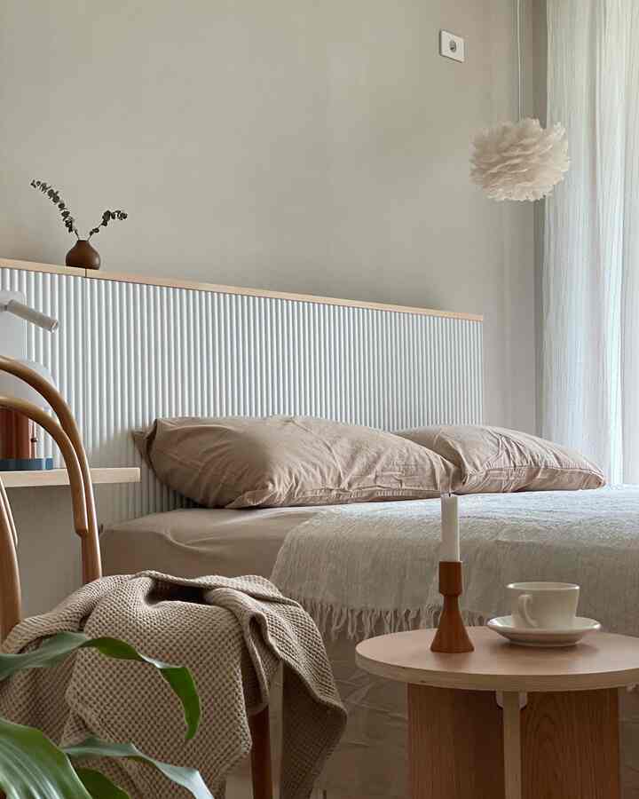 Beige and wood tone bedroom featuring a bed and nightstand with a candle, creating a natural atmosphere