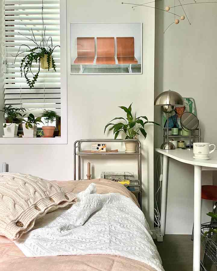 Beige and white toned bedroom featuring bed, desk, and plants with a natural and cozy atmosphere