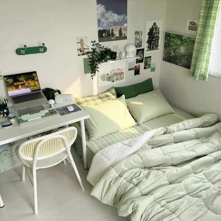 Green and ivory toned bedroom featuring a bed and desk in a cozy, compact space